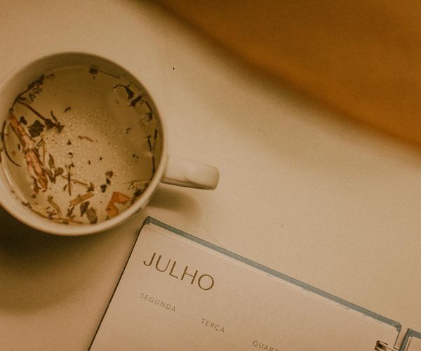 Calendar and a cup of tea symbolizing the integration of wellness into a daily routine.
